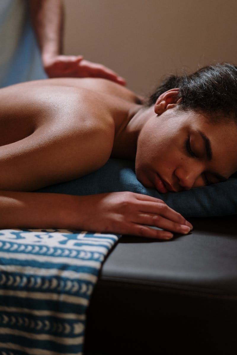 A woman enjoying a relaxing massage therapy session in a spa setting, promoting wellness and tranquility.